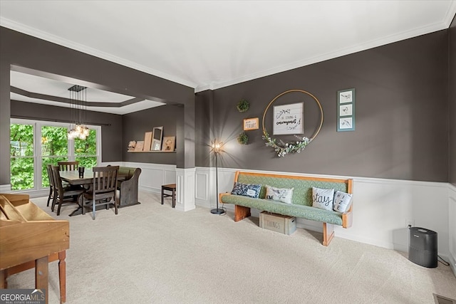 living room with light carpet, crown molding, a chandelier, and a tray ceiling