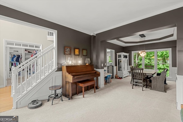 interior space with a notable chandelier, ornamental molding, carpet floors, and a raised ceiling