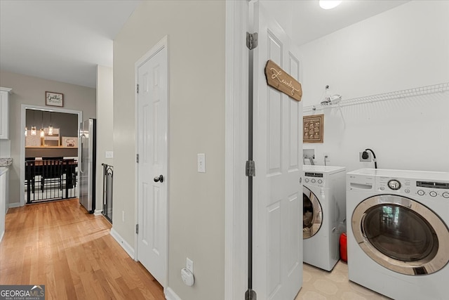 laundry room featuring light hardwood / wood-style flooring and washer and clothes dryer