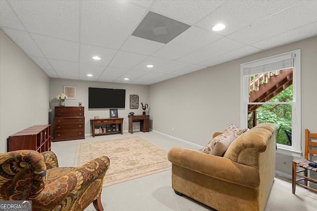 carpeted living room with a drop ceiling