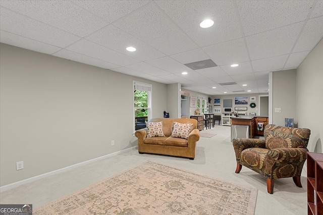 carpeted living room with a paneled ceiling