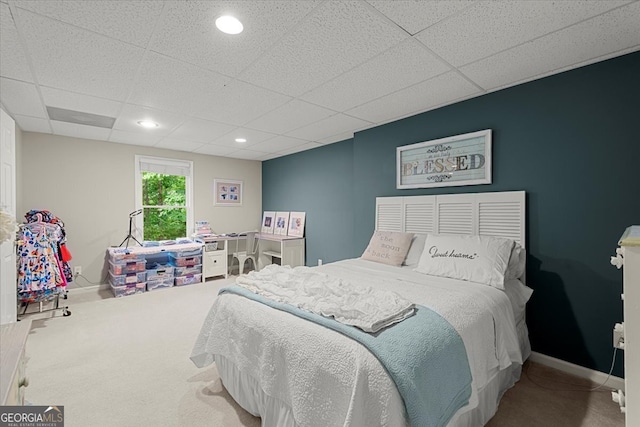 carpeted bedroom with a paneled ceiling