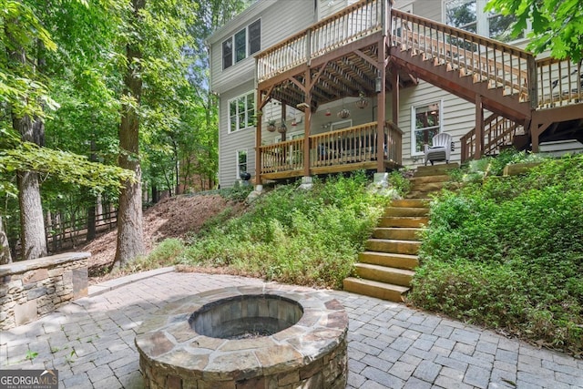 view of patio with a deck and an outdoor fire pit