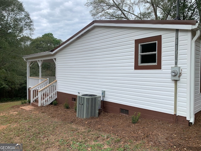 view of front of house with central AC and a front lawn