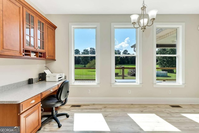 home office with light hardwood / wood-style flooring, a chandelier, and plenty of natural light