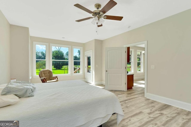 bedroom with multiple windows, light wood-type flooring, and ceiling fan