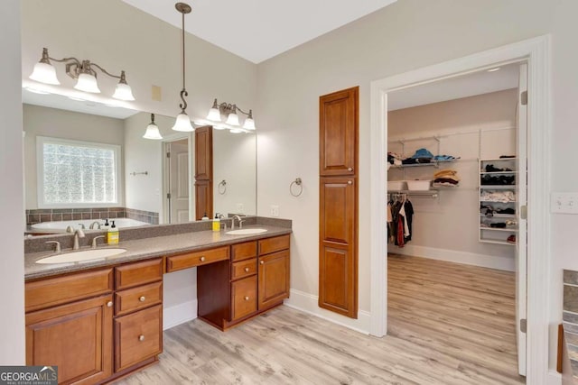 bathroom featuring dual vanity, a bath, and hardwood / wood-style floors