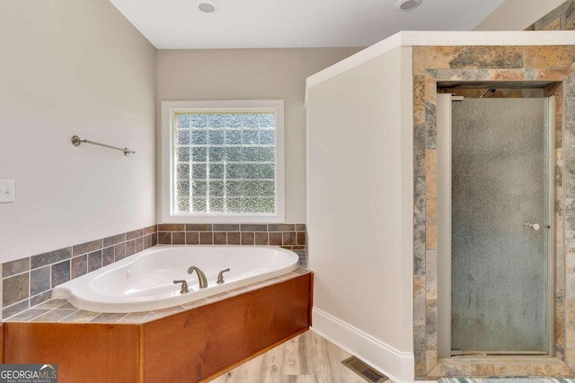 bathroom with hardwood / wood-style floors and separate shower and tub