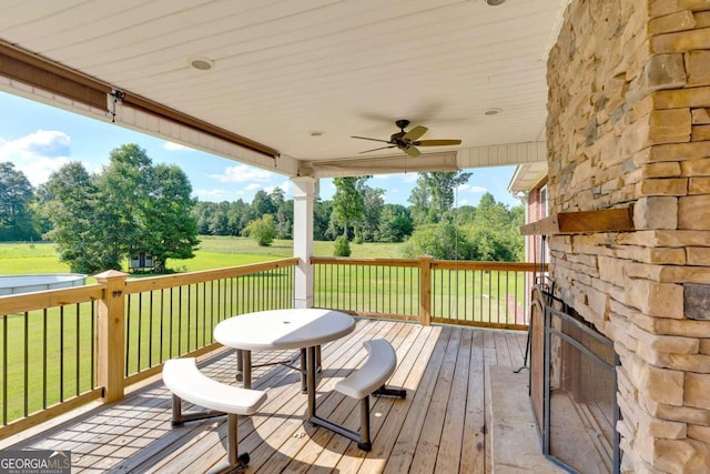 deck with a lawn and ceiling fan