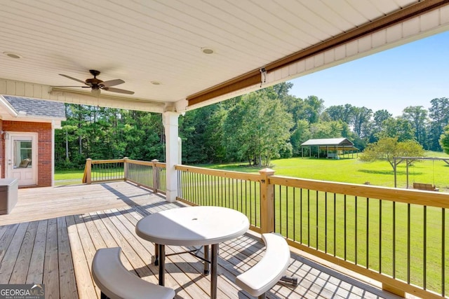 wooden terrace with a gazebo, ceiling fan, and a lawn