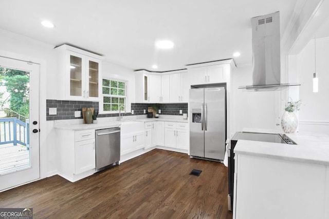 kitchen with decorative backsplash, appliances with stainless steel finishes, dark hardwood / wood-style floors, and wall chimney exhaust hood