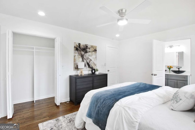 bedroom with dark hardwood / wood-style flooring, ceiling fan, sink, ornamental molding, and a closet