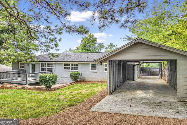 rear view of house featuring a yard and a carport