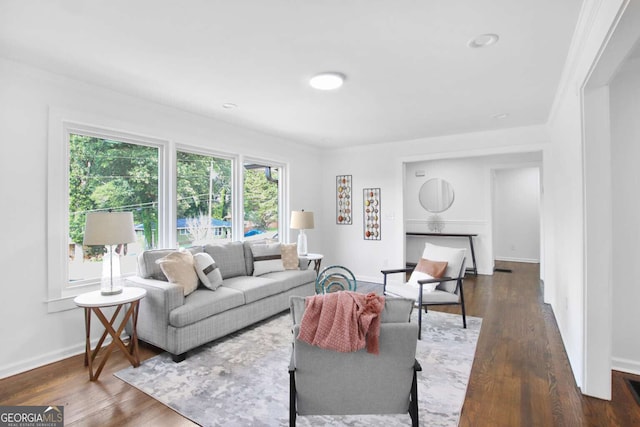 living room with dark hardwood / wood-style floors and crown molding