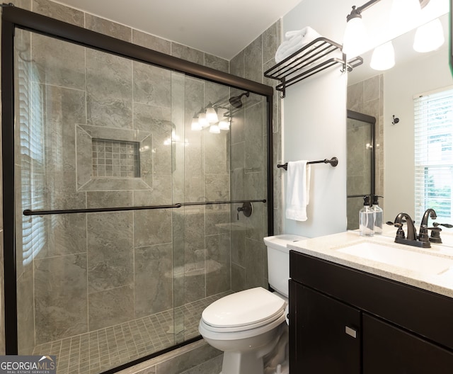 bathroom featuring vanity, toilet, and a shower with door