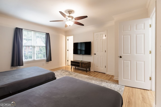 bedroom with ceiling fan, crown molding, and light hardwood / wood-style flooring