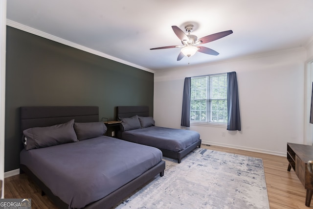 bedroom featuring wood-type flooring, ceiling fan, and ornamental molding