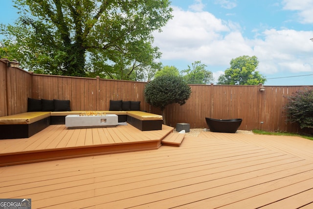 wooden deck with an outdoor living space with a fire pit