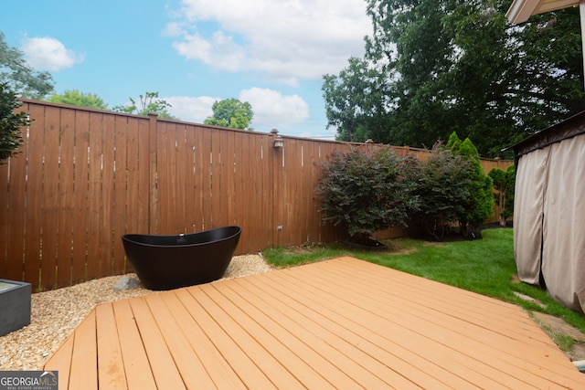 wooden deck featuring a lawn