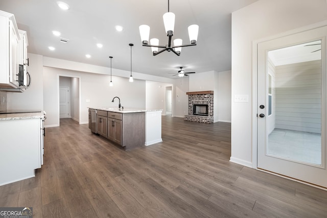 kitchen with decorative light fixtures, white cabinetry, dark hardwood / wood-style floors, and an island with sink