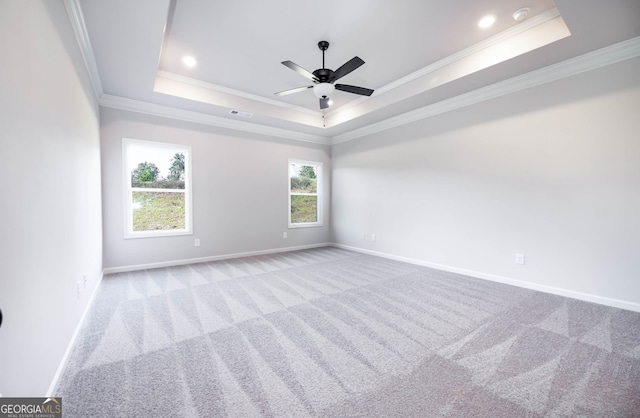 empty room featuring a tray ceiling, ceiling fan, and crown molding