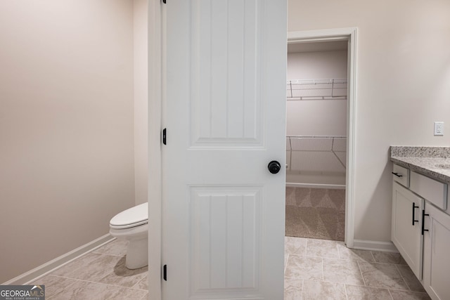 bathroom featuring tile patterned flooring, vanity, and toilet