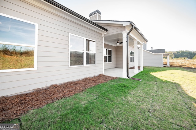 view of property exterior with a yard, ceiling fan, and a patio area