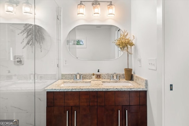 bathroom with dual vanity and an enclosed shower