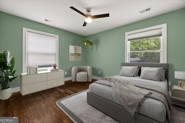 bedroom with dark hardwood / wood-style flooring and ceiling fan