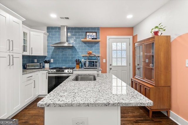 kitchen featuring white cabinetry, tasteful backsplash, wall chimney exhaust hood, appliances with stainless steel finishes, and dark wood-type flooring