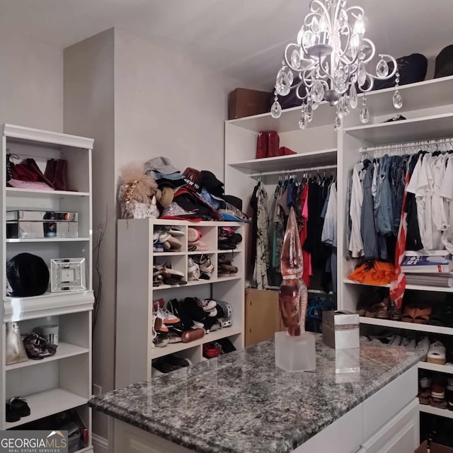 walk in closet featuring a notable chandelier