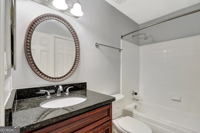 full bathroom featuring washtub / shower combination, toilet, a textured ceiling, and vanity