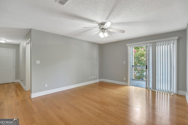 empty room with a textured ceiling, ceiling fan, and light hardwood / wood-style floors