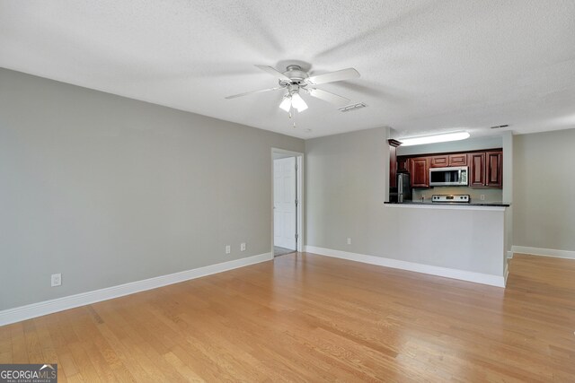 unfurnished living room with a textured ceiling, light hardwood / wood-style flooring, and ceiling fan