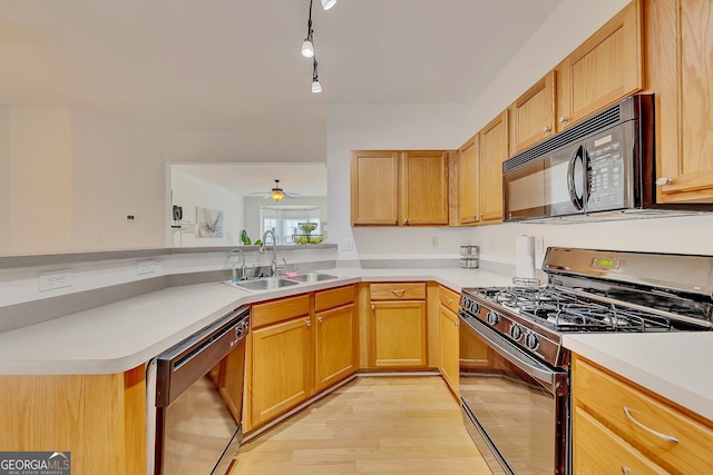 kitchen featuring dishwashing machine, light hardwood / wood-style flooring, ceiling fan, gas range, and sink