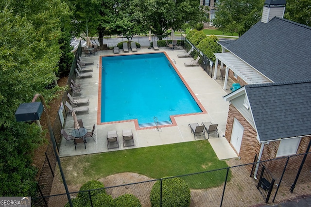 view of swimming pool featuring a patio and a yard