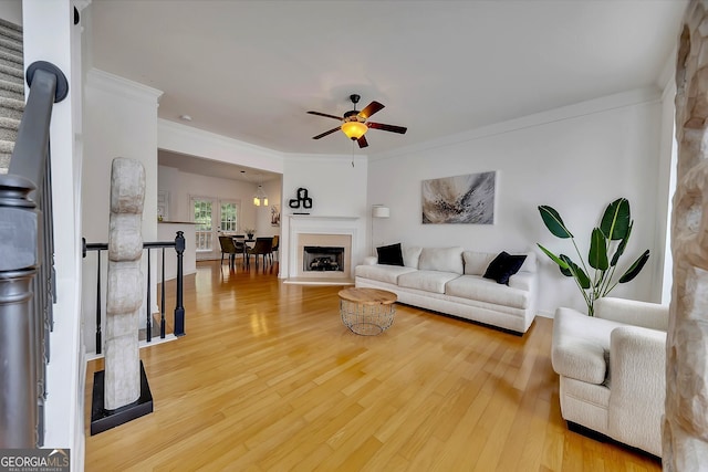 living room featuring light hardwood / wood-style floors, crown molding, and ceiling fan