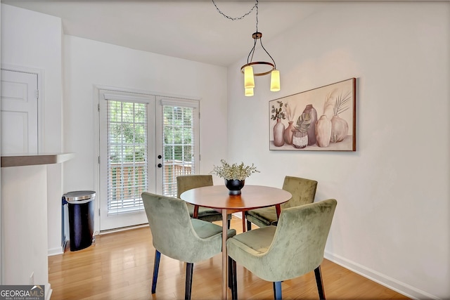 dining space featuring a healthy amount of sunlight, light hardwood / wood-style floors, and french doors