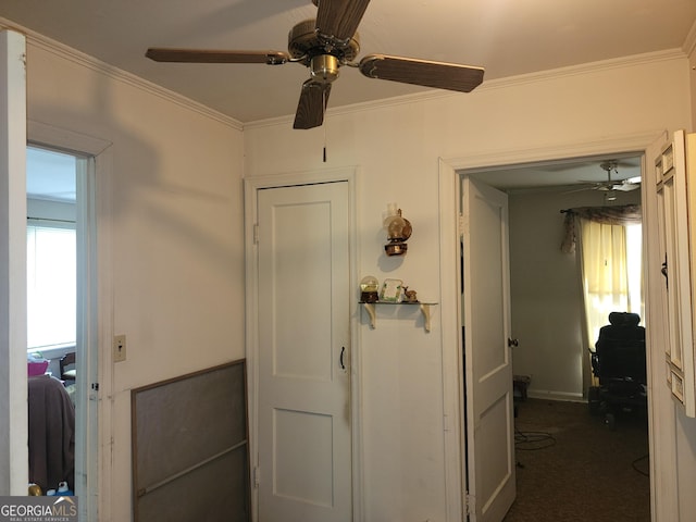 corridor featuring ornamental molding and dark colored carpet