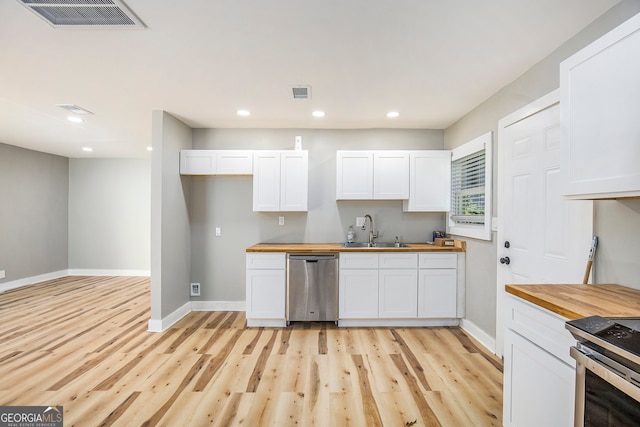 kitchen featuring light wood-type flooring, white cabinets, stainless steel appliances, and butcher block countertops