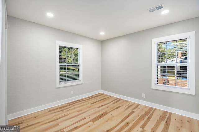 unfurnished room with light wood-type flooring and a wealth of natural light