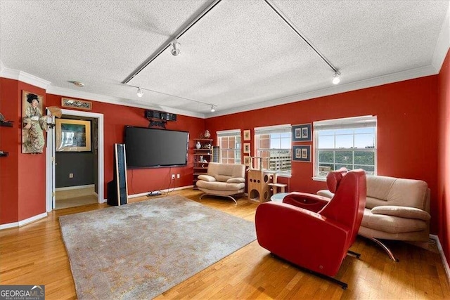 living room featuring ornamental molding, a textured ceiling, and wood finished floors