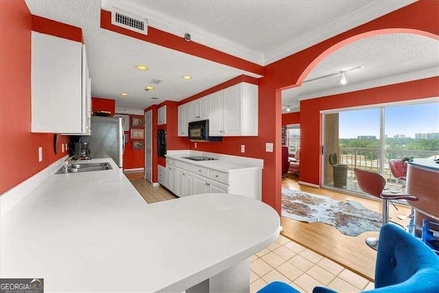 kitchen with white cabinets, a sink, visible vents, and black appliances