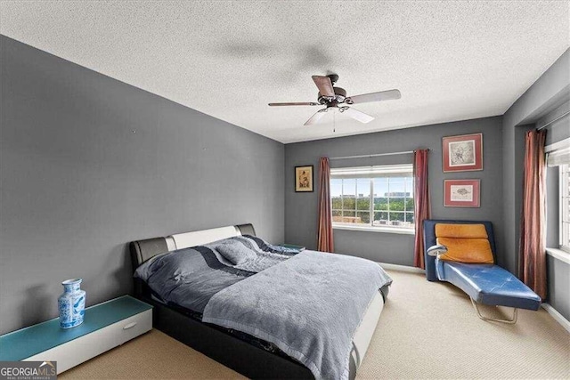 carpeted bedroom featuring ceiling fan, a textured ceiling, and baseboards