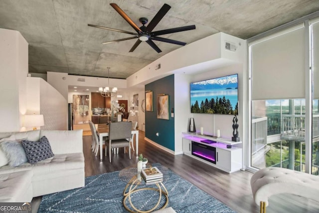 dining area featuring hardwood / wood-style flooring, ceiling fan with notable chandelier, and a wall of windows