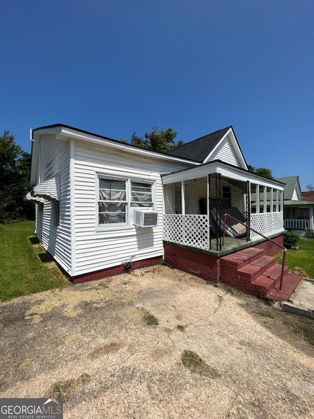 back of house with covered porch and cooling unit