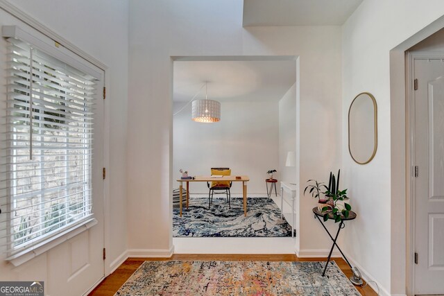 entryway with hardwood / wood-style flooring and a chandelier