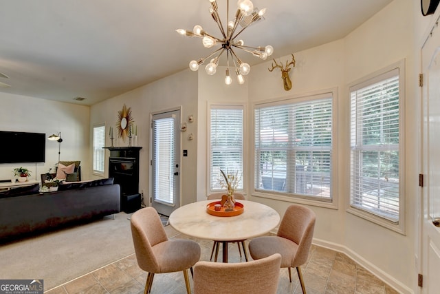 carpeted dining area with a healthy amount of sunlight and an inviting chandelier