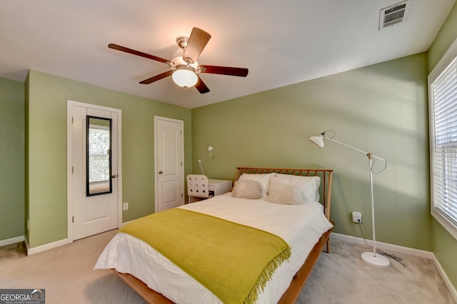 bedroom with light carpet, multiple windows, and ceiling fan