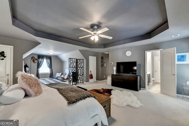 bedroom with ceiling fan, carpet floors, and a tray ceiling